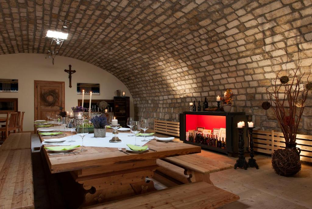 a dining room with a table and a brick wall at Remushof Jagschitz in Oslip