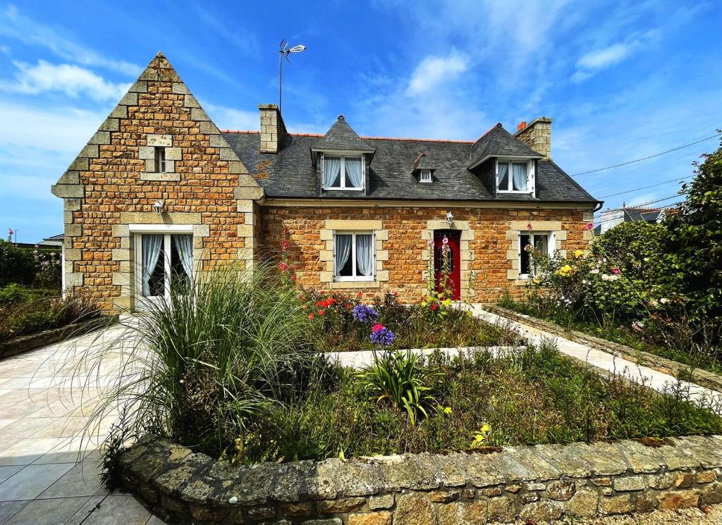 une maison en briques avec un jardin devant dans l'établissement Steredennvor, à Pleubian
