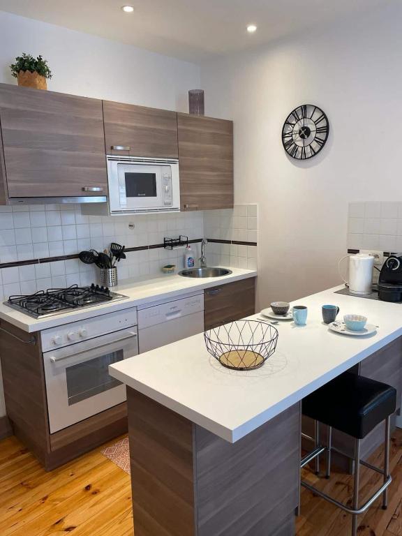 - une cuisine avec un comptoir et une cuisinière four supérieur dans l'établissement LE SAINT JULIEN 3étoiles - Hypercentre - Proche Thermes - Balcon, à Vichy