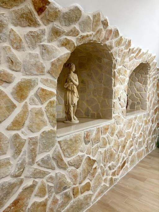 una estatua de una mujer en un muro de piedra en Mariposa Suite, en Manfredonia