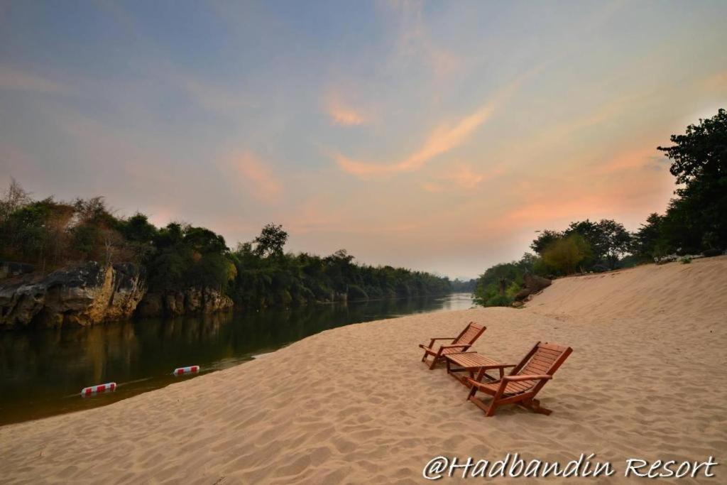 zwei Bänke an einem Strand neben einem Fluss in der Unterkunft Had Ban Din Resort in Ban Nong Pru
