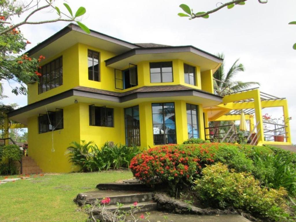 a yellow house with some flowers in front of it at Ticao Altamar Boutique Resort in Tahiran