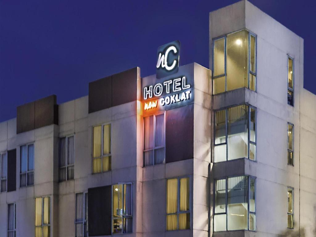 a hotel building with a sign on top of it at Hotel New Coklat in Surabaya