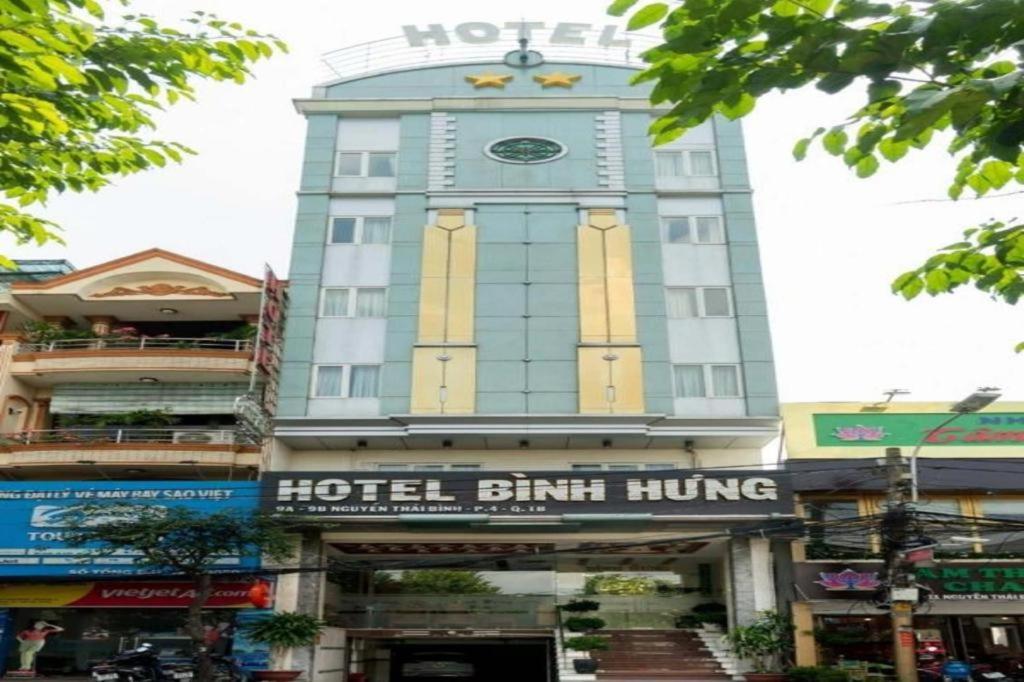 Binh Hung Hotel في مدينة هوشي منه: مبنى فندقي به ساعة في أعلاه
