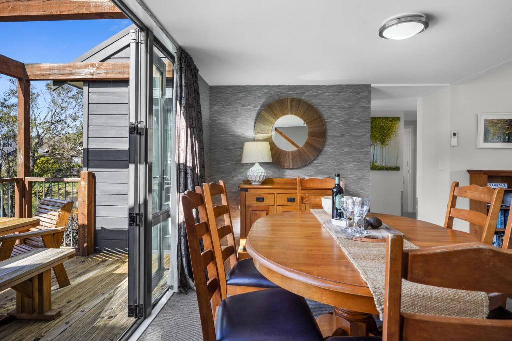 Un comedor con mesa y sillas de madera. en *** LAKE VILLA 460 ***, en Hanmer Springs