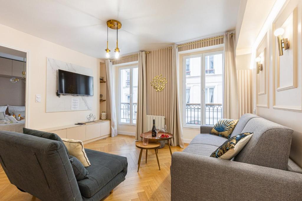 un salon avec deux canapés et une télévision dans l'établissement Bluestay 159 - Charmant appartement à Paris 2, à Paris