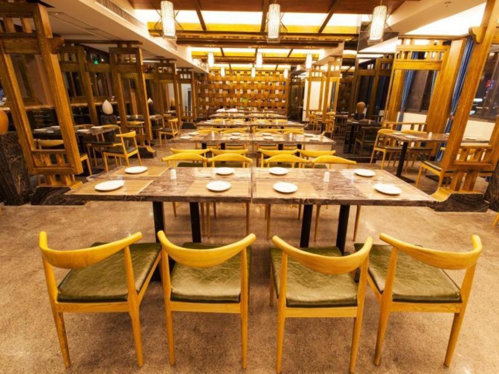 ein großes Esszimmer mit einem großen Tisch und Stühlen in der Unterkunft Zhangjiajie Xiangfu International Hot Springs Hotel in Zhangjiajie