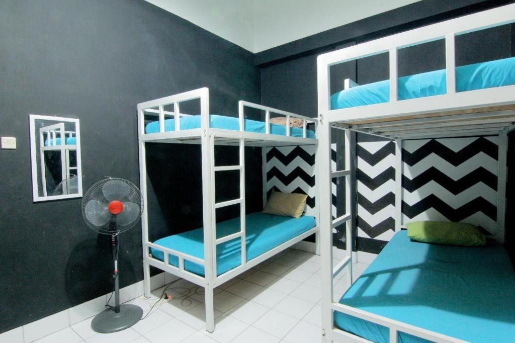 a bedroom with two bunk beds with blue sheets at Hostel Backpackers 44 in Yogyakarta