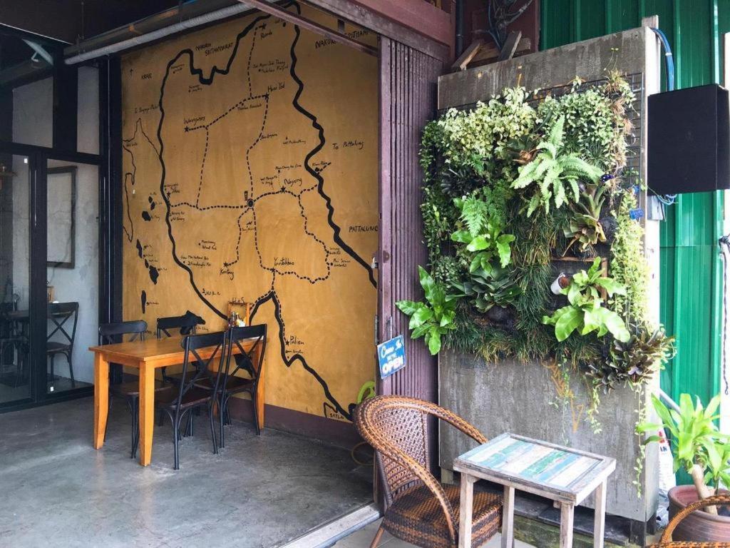 a room with a table and a map on the wall at Sritrang Hotel in Trang