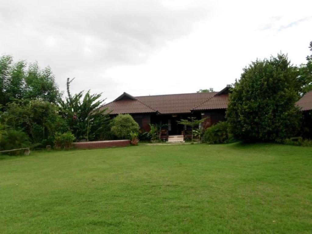 ein Haus mit einer großen Wiese davor in der Unterkunft Phu Resort in Ban Choko