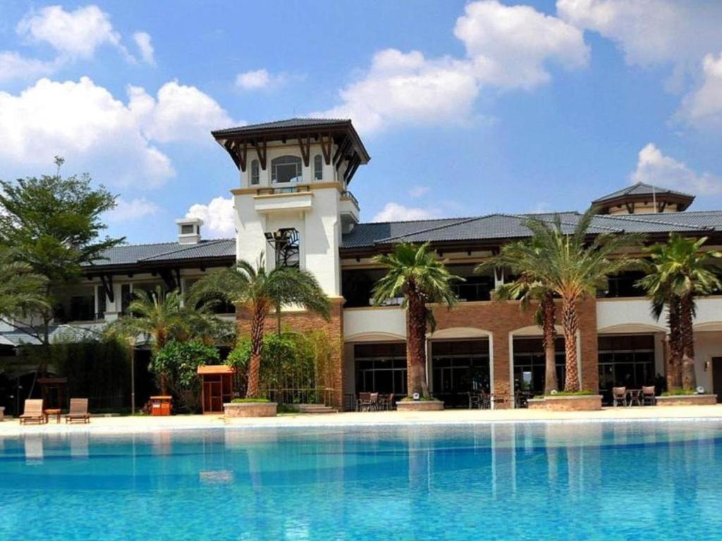 a hotel with a swimming pool in front of a building at Country Garden Holiday Hotel Fogang Hot Spring in San-pa