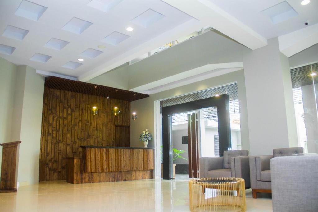 eine Lobby mit einem Wartebereich mit Stühlen und einem Tisch in der Unterkunft HOTEL GRAND KUTILANG SYARIAH in Lampung