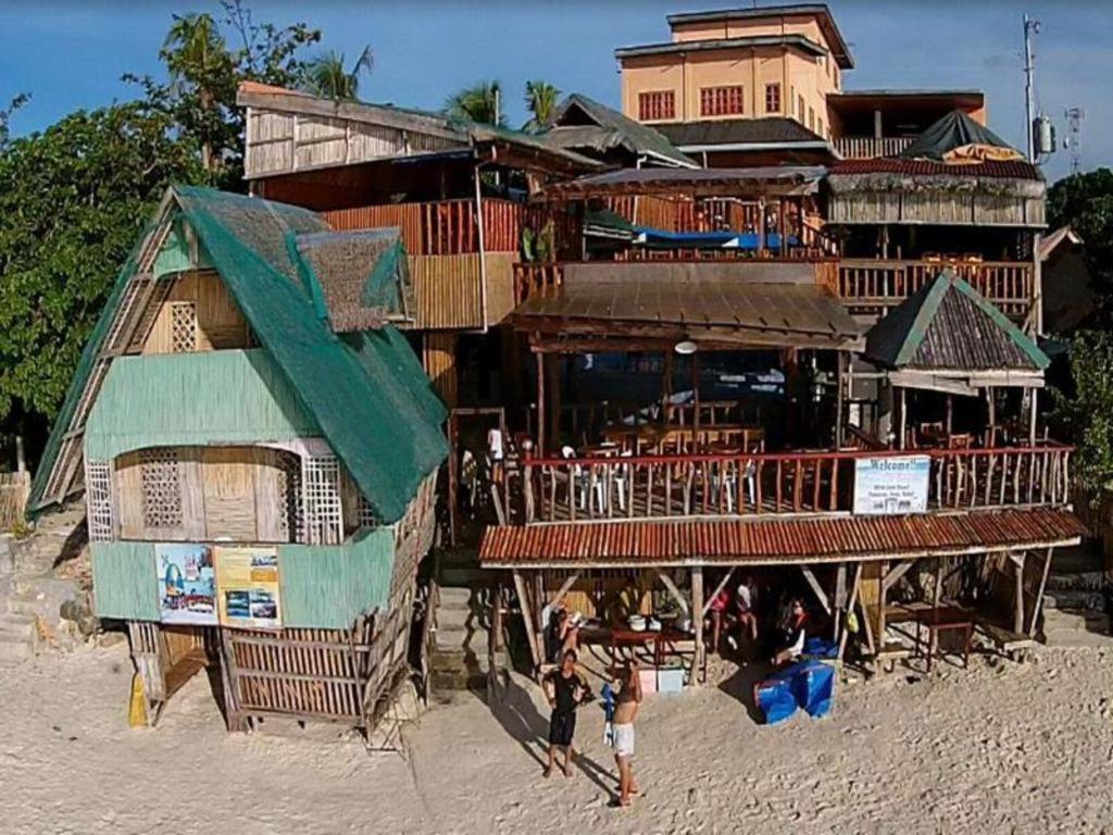 a building on the beach with people in front of it at Anda de Boracay in Bohol Hotel in Anda