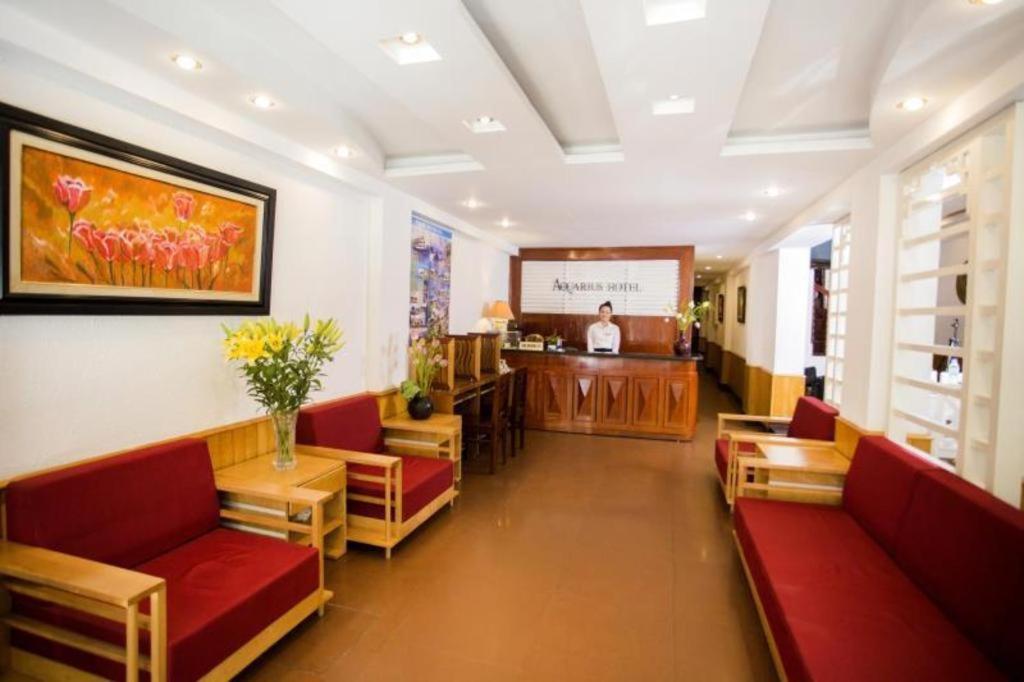 a waiting room with red couches and a podium at Aquarius Hotel in Hanoi