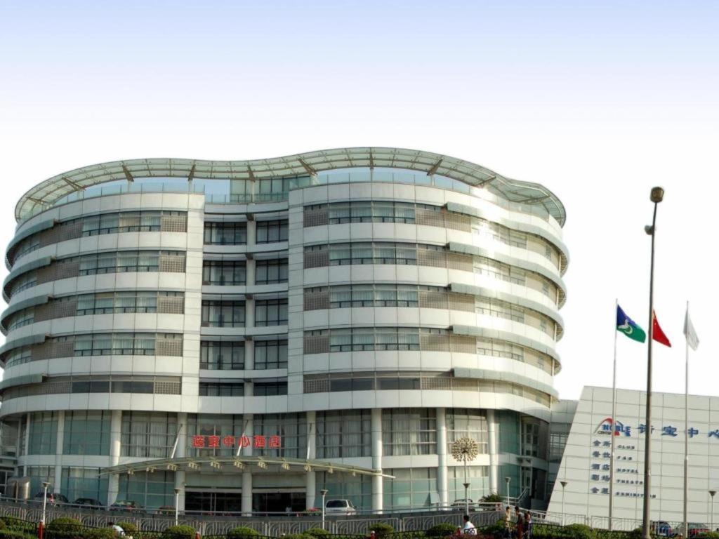 上海市にあるShanghai Noble Centerの旗が目の前に掲げられた大きなガラス張りの建物