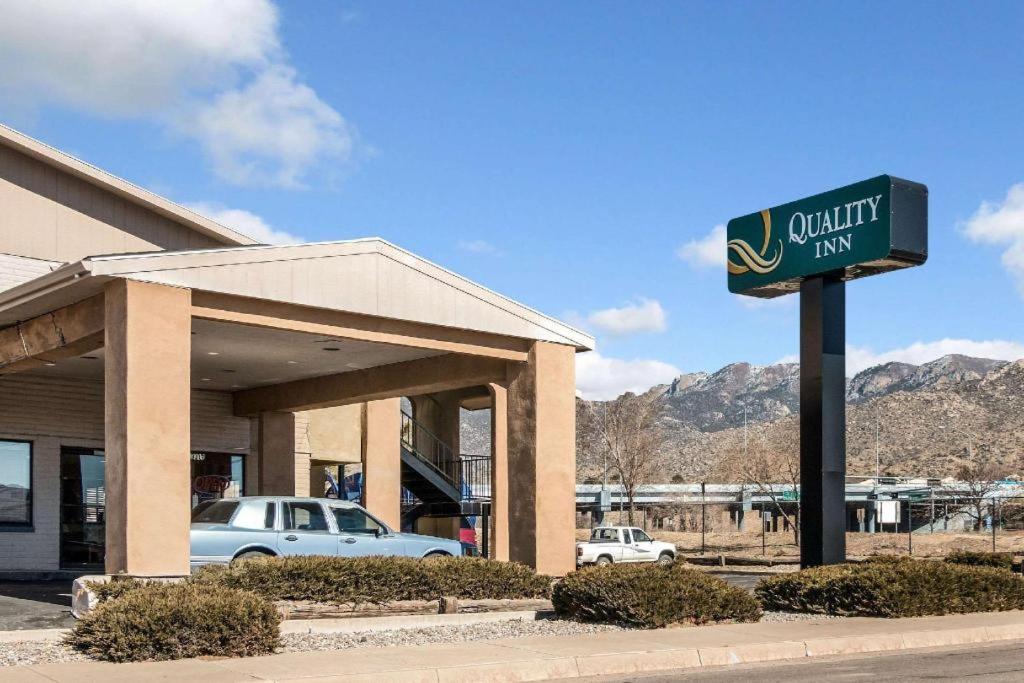 a sign for a california inn with a car dealership at Quality Inn in Albuquerque