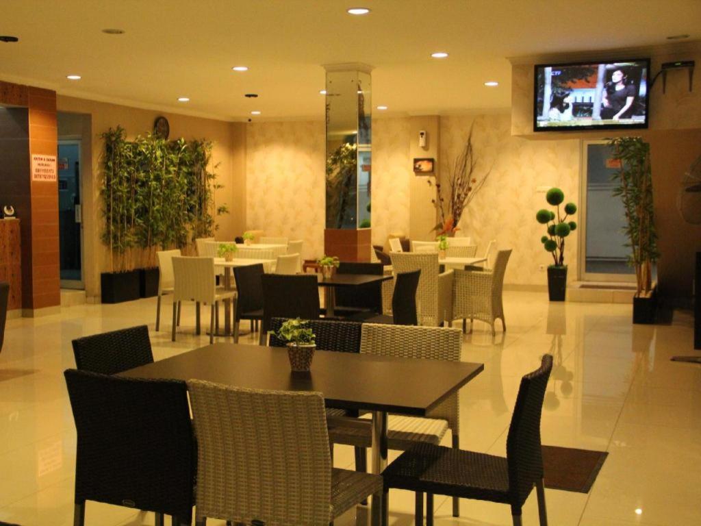 a restaurant with tables and chairs and a tv on the wall at Flamengo Hotel in Gedeg