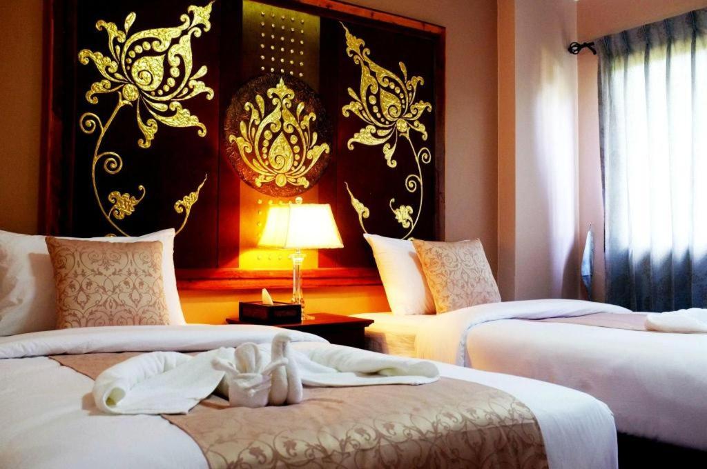 a hotel room with two beds with towels on them at Ladawan Boutique Hotel in Ban Pak Khlong