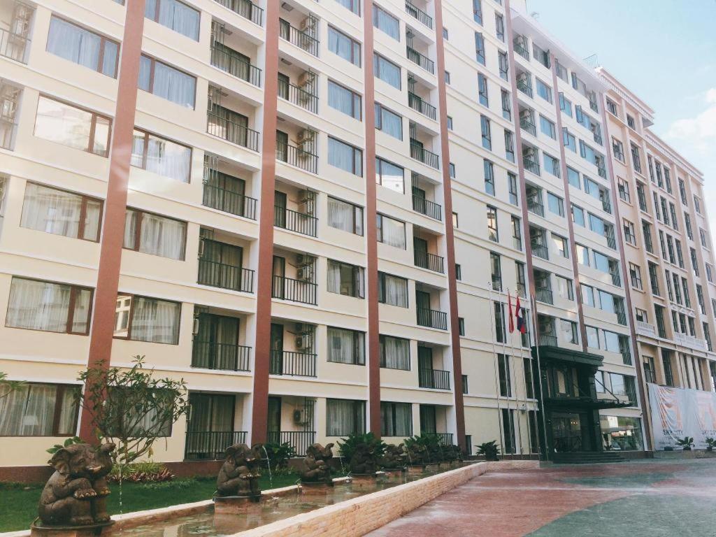 a large white building with a fountain in front of it at Sky City Hotel in Ban Phôn Khéng
