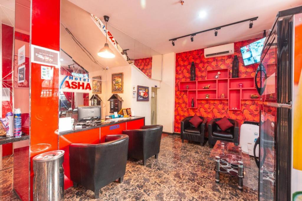 ein Restaurant mit roten Wänden und schwarzen Stühlen in der Unterkunft OYO 1737 Hotel Celvasha in Jakarta