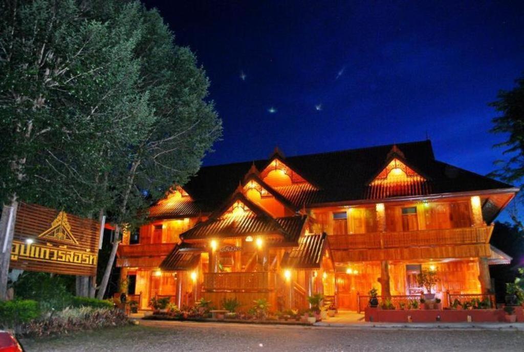 a large wooden house with lights on it at night at Oopkaew Resort in Pua