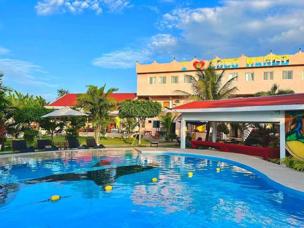 a large swimming pool in front of a hotel at Coco Mango's Place in Panglao