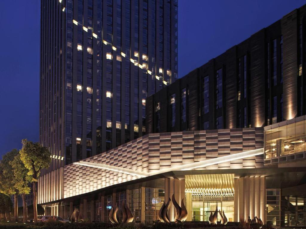 a large building with a lit up facade at night at Chongqing The Lotus Hotel in Chongqing