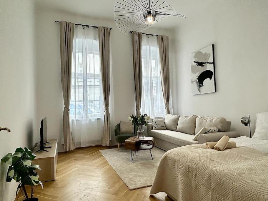Sala de estar blanca con cama y sofá en Close to Metro, 10 Minutes to Mariahilferstraße, en Viena