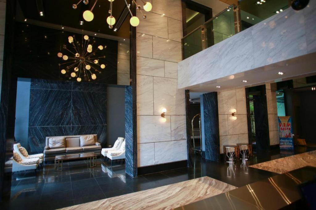 eine Lobby mit einem Sofa und Stühlen in einem Gebäude in der Unterkunft Holiday Poipet in Ban Khok (1)