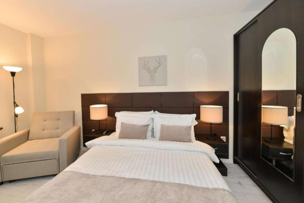 a bedroom with a large bed and a chair at Art Plaza Hotel in Sofia