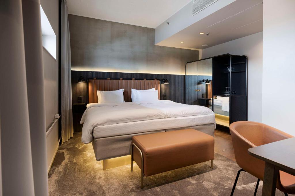 a hotel room with a large bed and a table at Radisson Blu Seaside Hotel, Helsinki in Helsinki