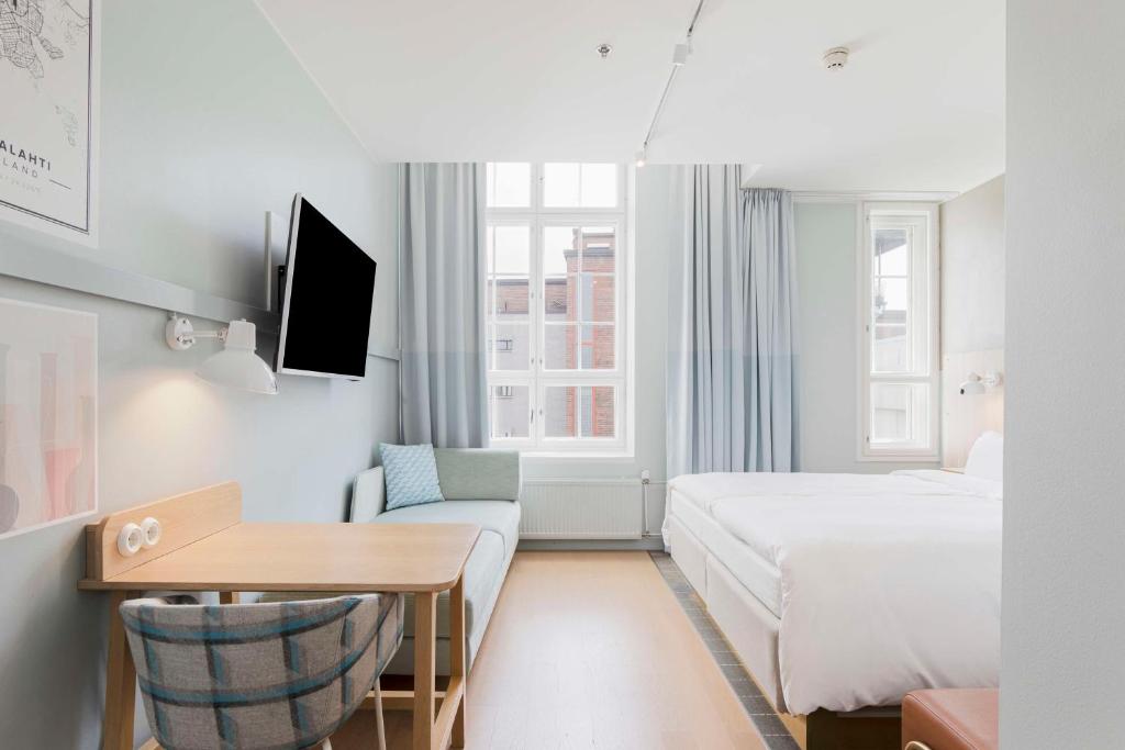 a hotel room with a bed and a desk at Radisson Blu Seaside Hotel, Helsinki in Helsinki