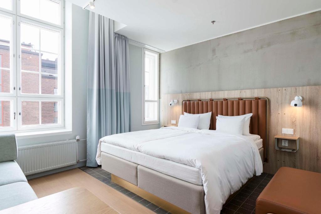 a bedroom with a large white bed and two windows at Radisson Blu Seaside Hotel, Helsinki in Helsinki