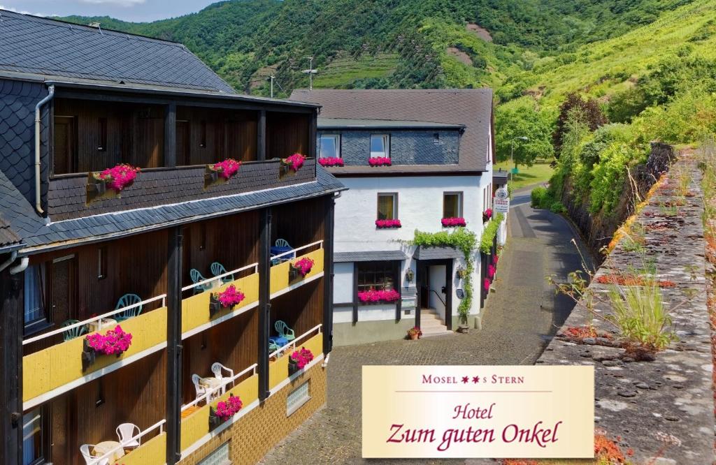 un edificio con flores a un lado. en Moselstern Hotel Zum guten Onkel, en Bruttig-Fankel