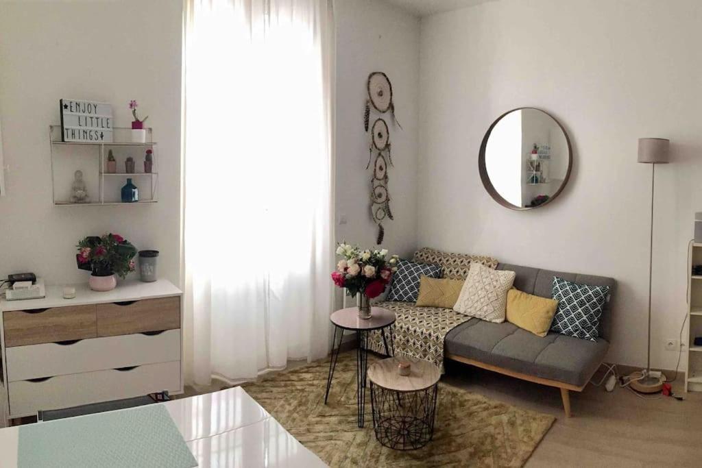 un salon avec un canapé et un miroir dans l'établissement Cozy Flat, 5 mins from metro, 1 bedroom, à Paris
