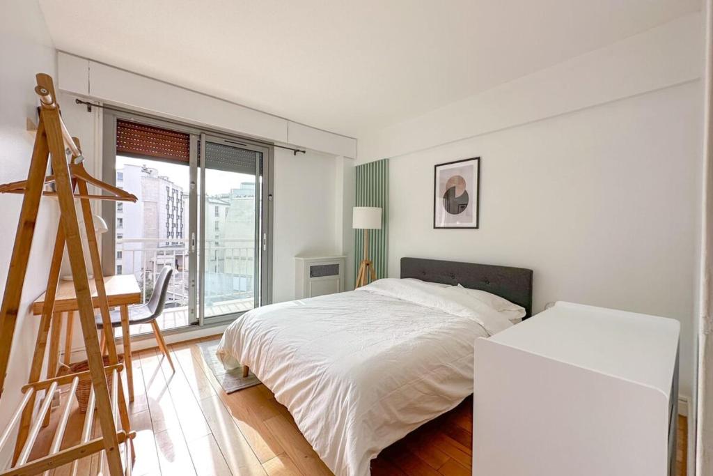 - une chambre blanche avec un lit et une échelle dans l'établissement Flexliving - room - Ternes, à Paris