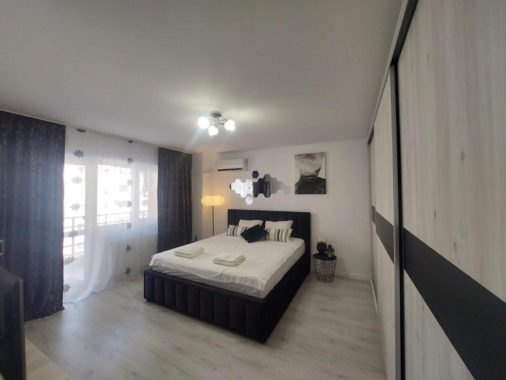 a bedroom with a bed and a large window at CC Studio in Popeşti-Leordeni