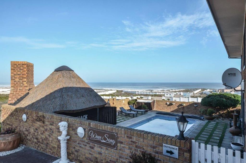 a resort with a swimming pool and a view of the ocean at Wave song in Yzerfontein