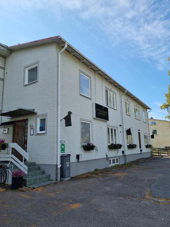 a white building with a sign on the side of it at Hotell Zlafen Bed and Breakfast in Karlskoga