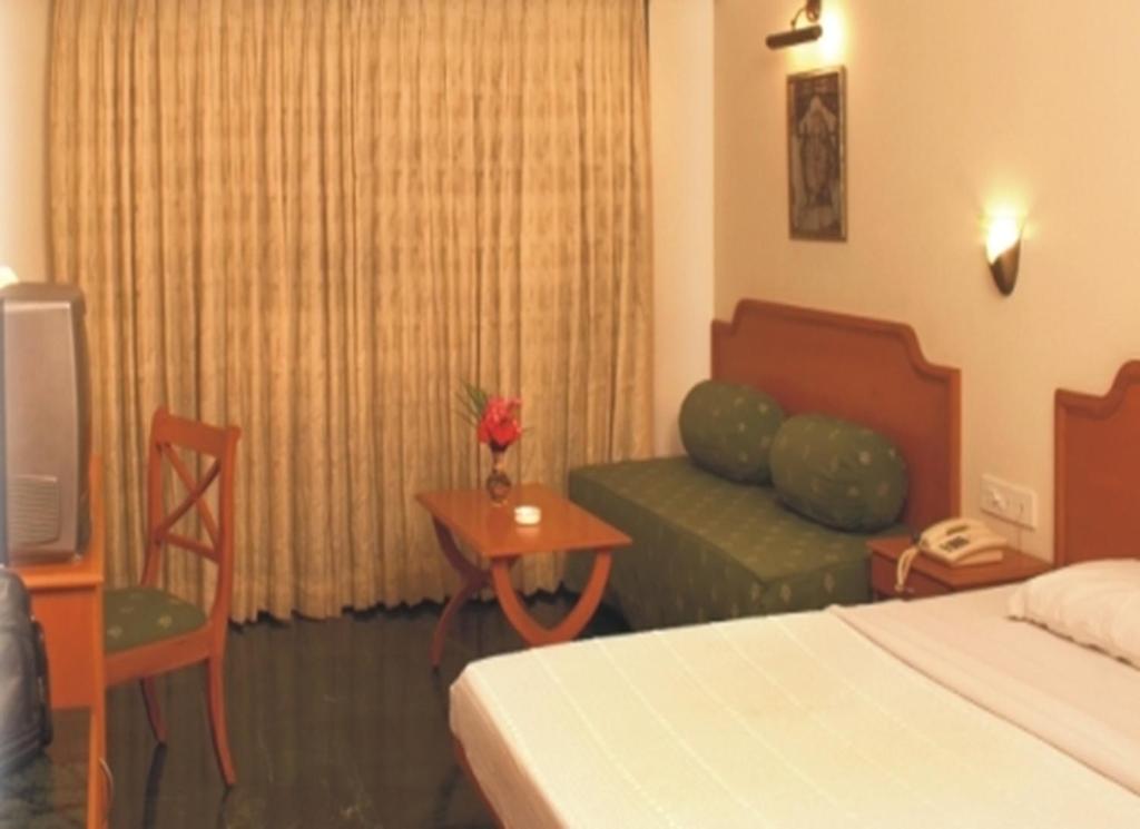 Postel nebo postele na pokoji v ubytování Renest Shraddha Inn - Shirdi