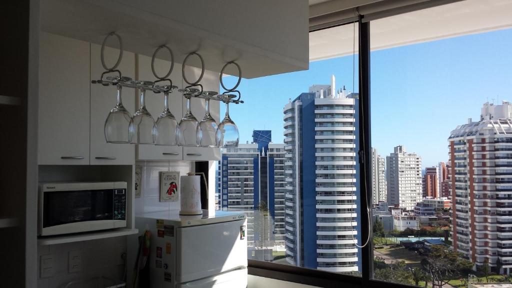 una cocina con vistas a la ciudad desde una ventana en Luminoso Apartamento en Aidy Grill, en Punta del Este