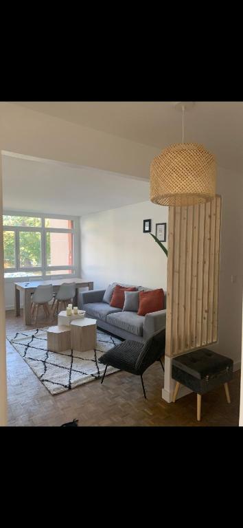 un salon avec un canapé et une table dans l'établissement Charmant appartement au calme, à Maisons-Laffitte