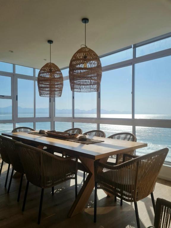 a dining room with a table and chairs and windows at Point Village Accommodation - Ocean Two 43 in Mossel Bay