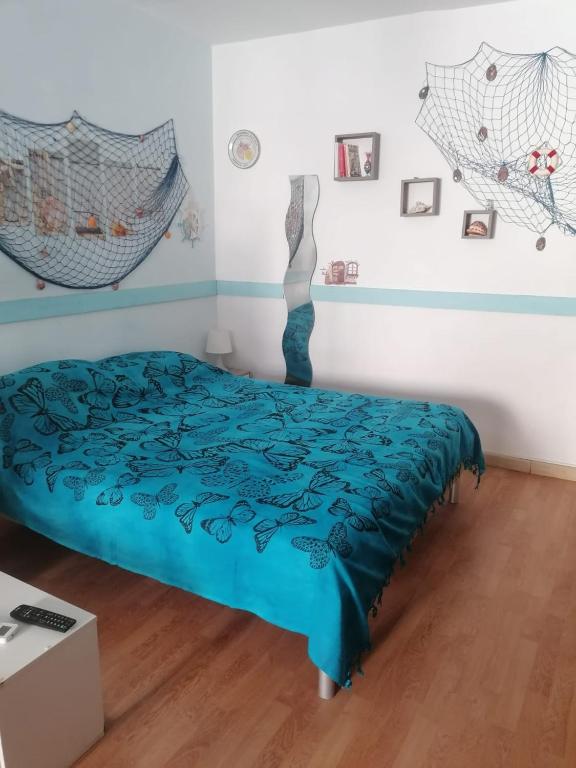 sypialnia z łóżkiem z niebieską kołdrą w obiekcie Salotto Mergellina w mieście Neapol
