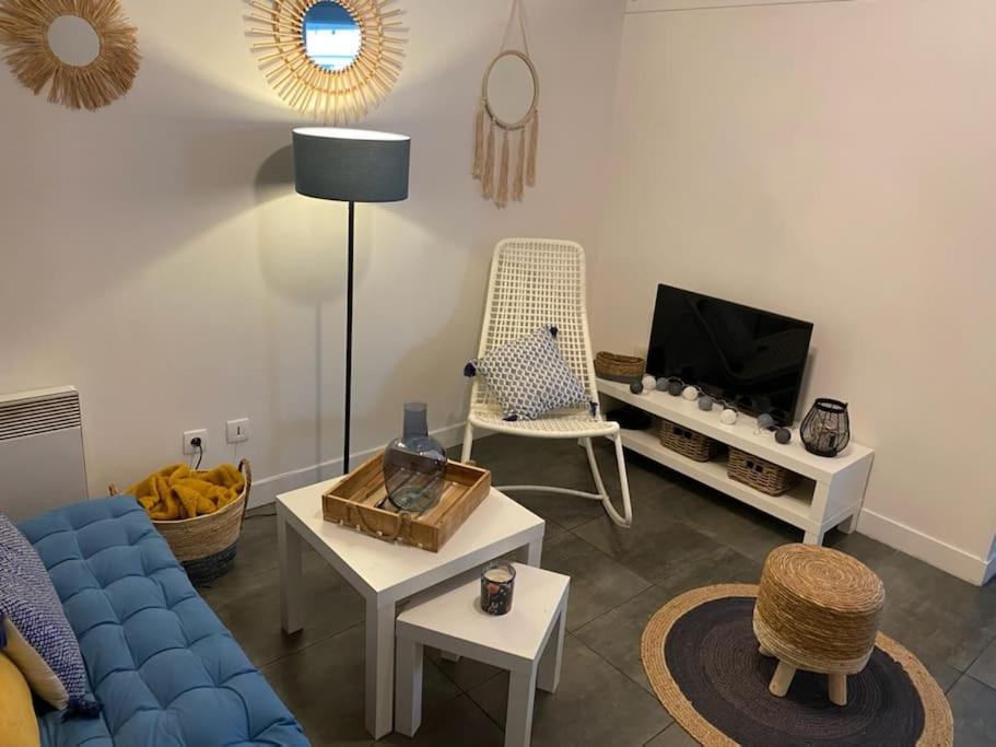 un salon avec un canapé bleu et une télévision dans l'établissement Appartement proche conservatoire hyper centre, à Reims