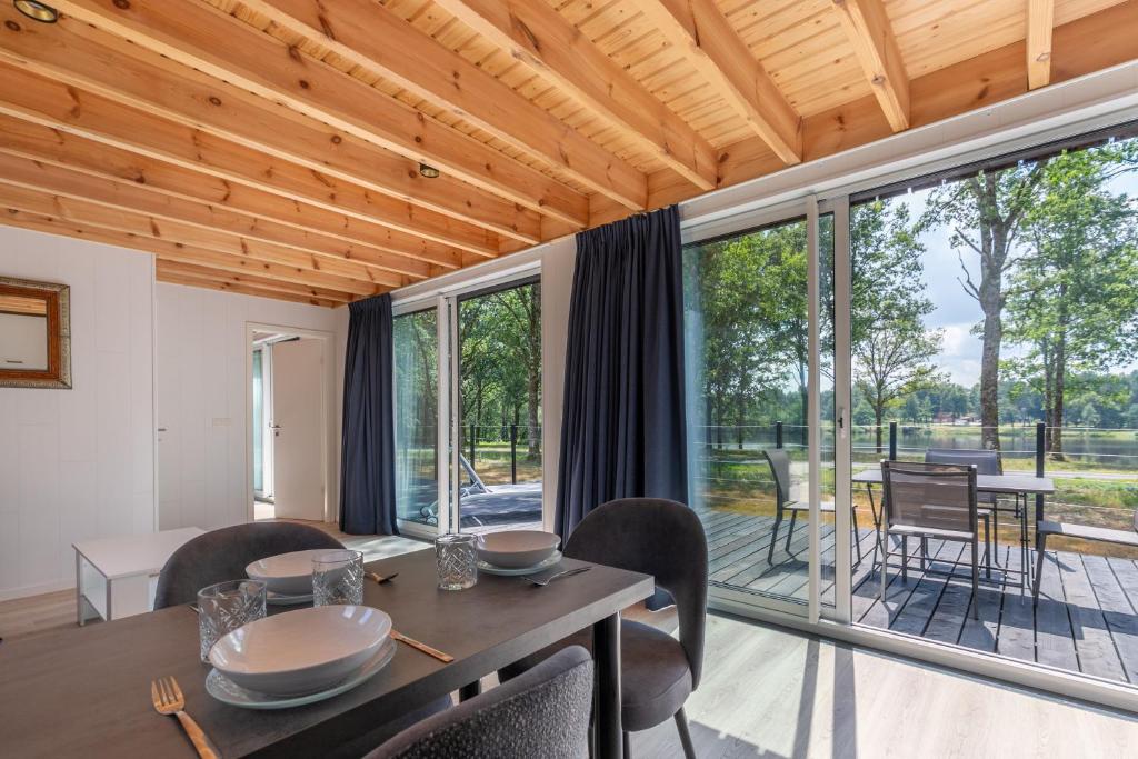 - une salle à manger avec une table, des chaises et de grandes fenêtres dans l'établissement Lodge 