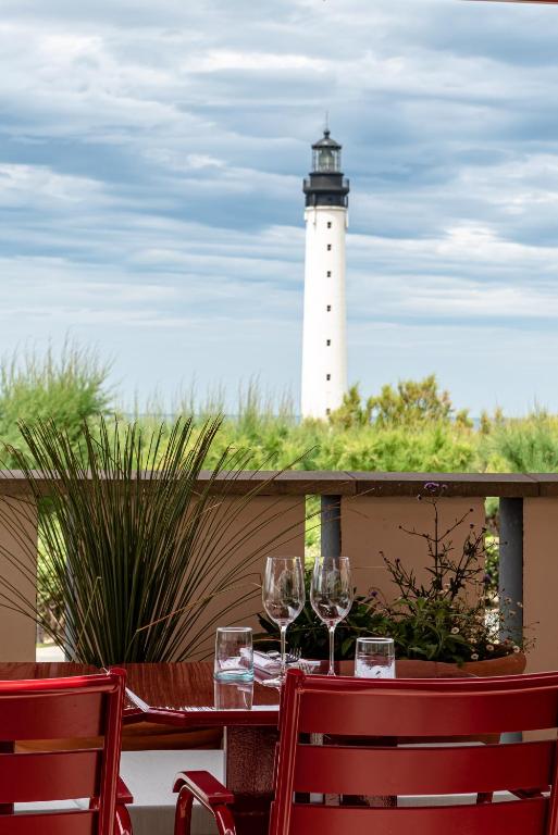 a table with two wine glasses and a lighthouse at Regina Experimental Biarritz in Biarritz