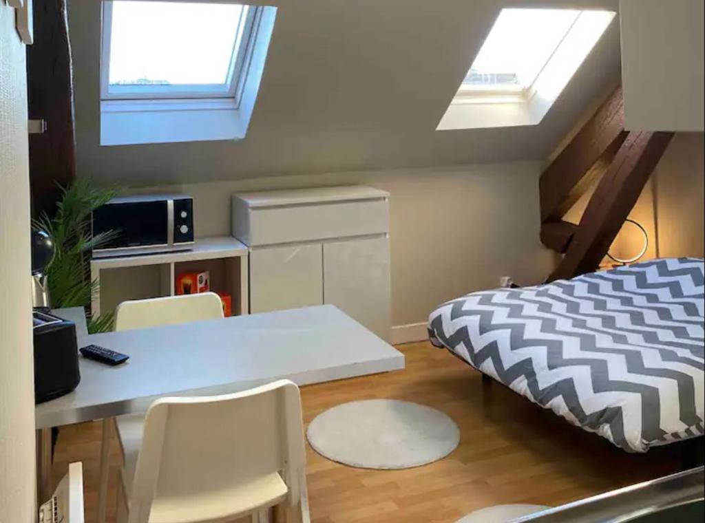 une chambre avec un lit, une table et des chaises dans l'établissement Studio rénové gare Dijon, à Dijon