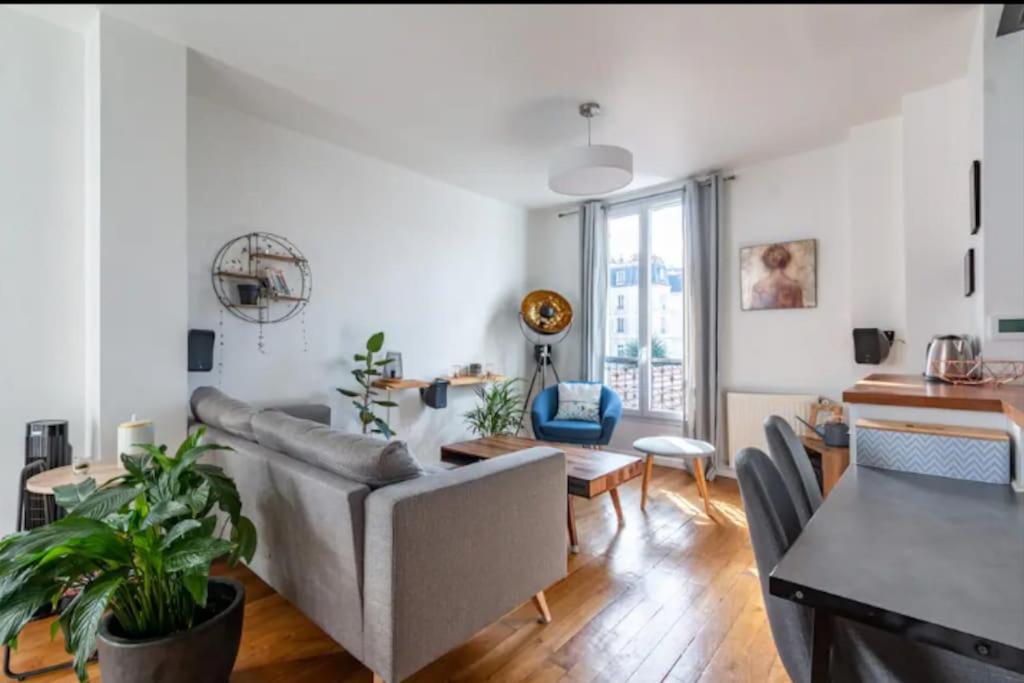 a living room with a couch and a table at Le Loft de l'Artiste in Sèvres