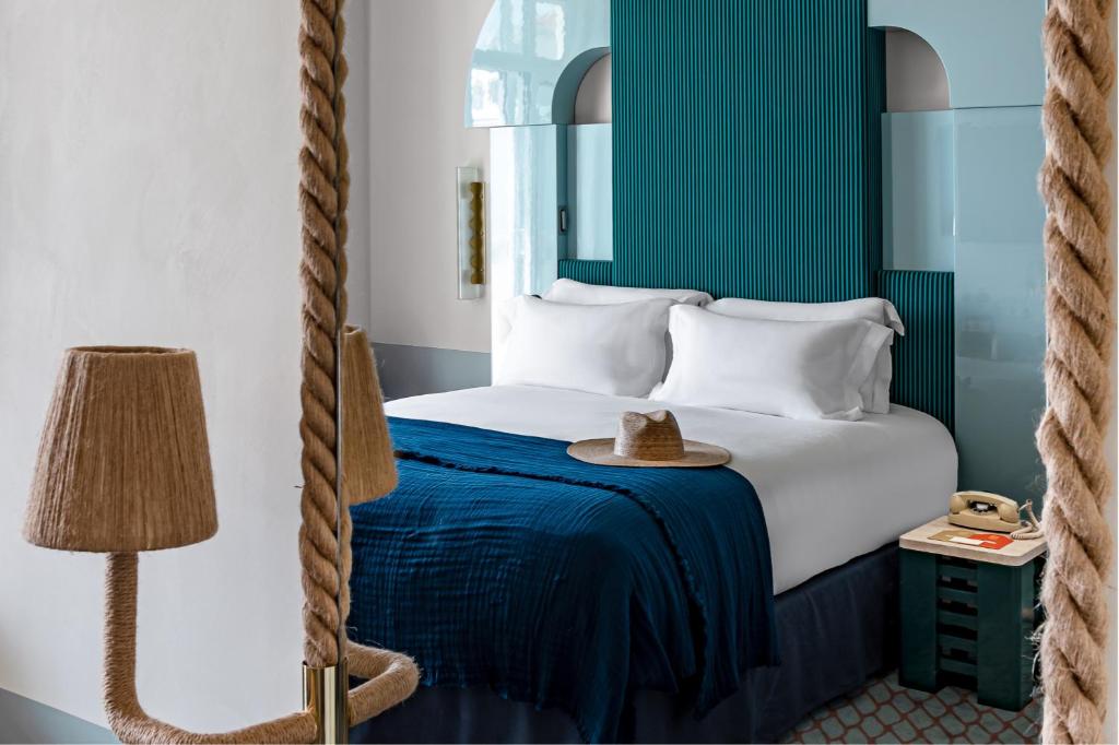 a hotel room with a bed with a hat on it at Regina Experimental Biarritz in Biarritz